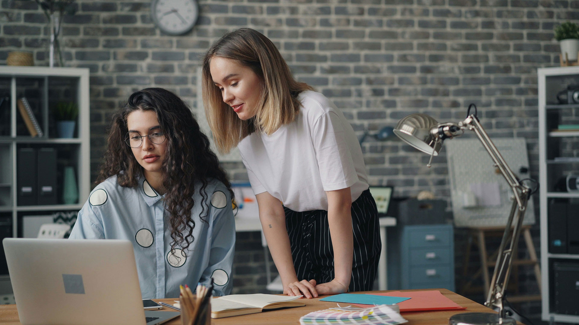Two people collaborating at a desk with a laptop